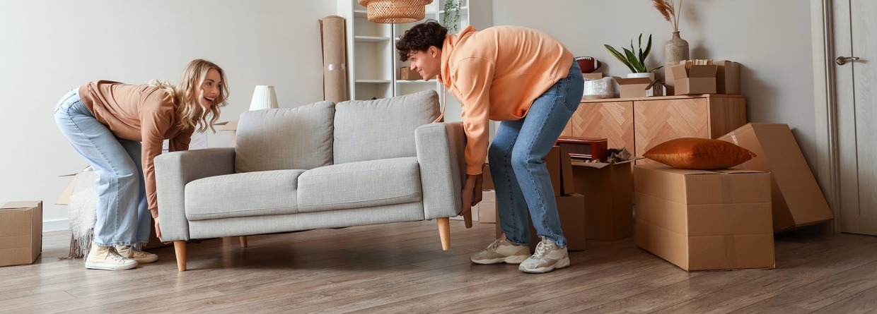 Jonge mensen tillen en plaatsen een bank tijdens de verhuizing in een woonkamer